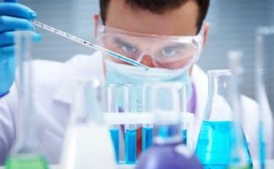 Investigator checking test tubes. Man wears protective goggles