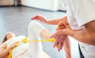 Unrecognizable senior physiotherapist working with a young female patient.